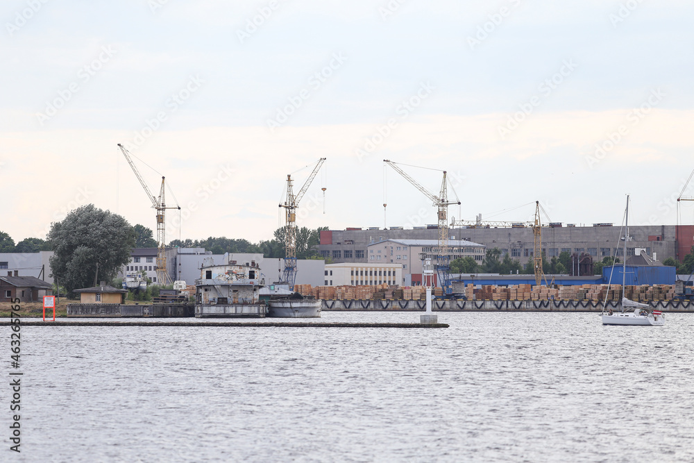 Industrial riverside view of commercial buildings and boating pier.