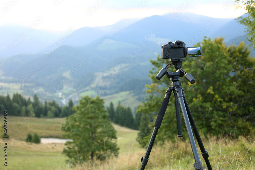 Taking video with modern camera on tripod in mountains Taking video with modern camera on tripod in mountains