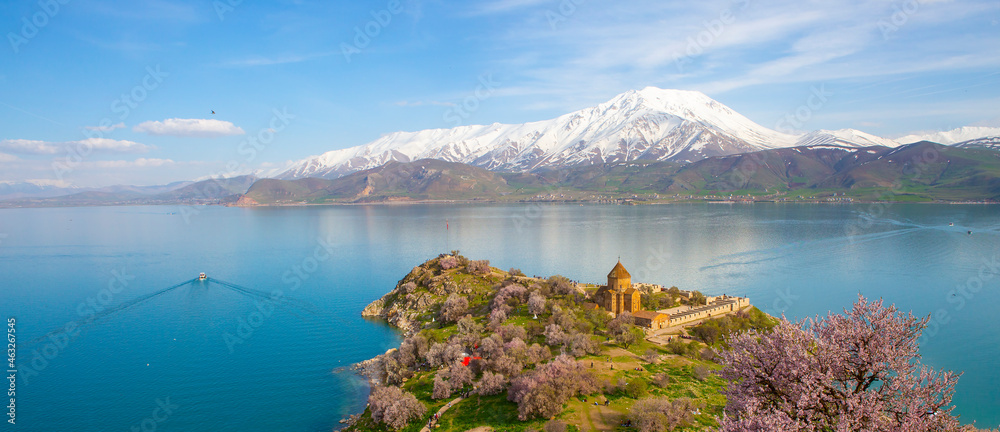 ‘Armenian Holy Cross Cathedral’ surrounded by tree in blossom, in a middle of ‘Akdamar Island’ Akdamar Adasi, Lake Van, Turkey.