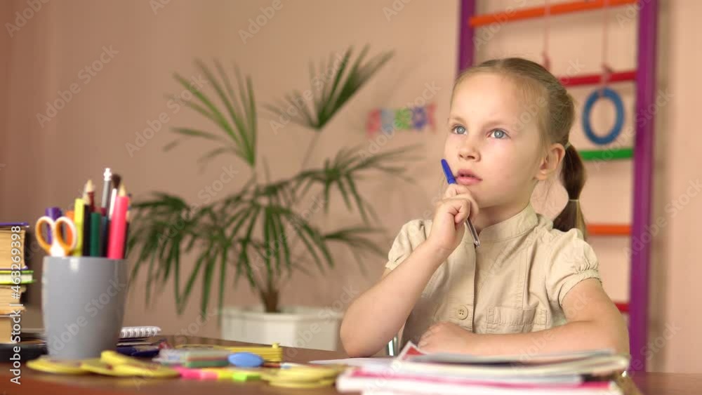 Preschooler is thinking while sitting at the table. She does her homework.4k Preschooler is thinking while sitting at the table. She does her homework.4k