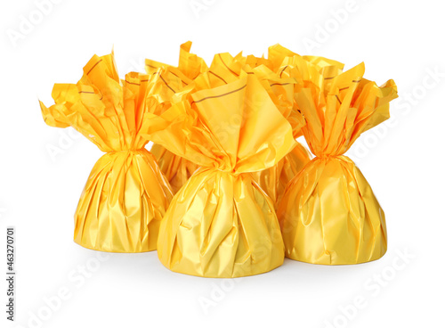 Delicious candies in yellow wrappers on white background