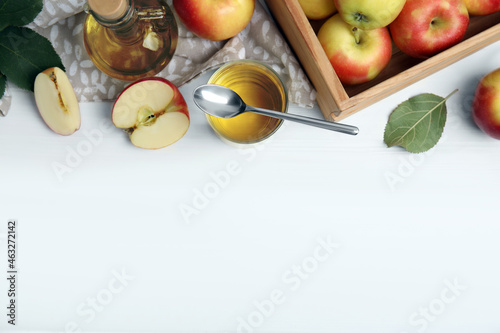 Natural apple vinegar and fresh fruits on white wooden table, flat lay. Space for text