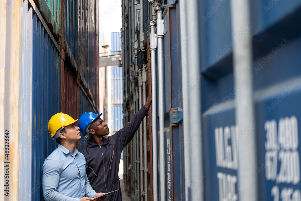 Selective focus at African black worker while talk and having discussion with supervisor and inspect the condition of all containers shipment, People and worker in freight deliver, import and export.