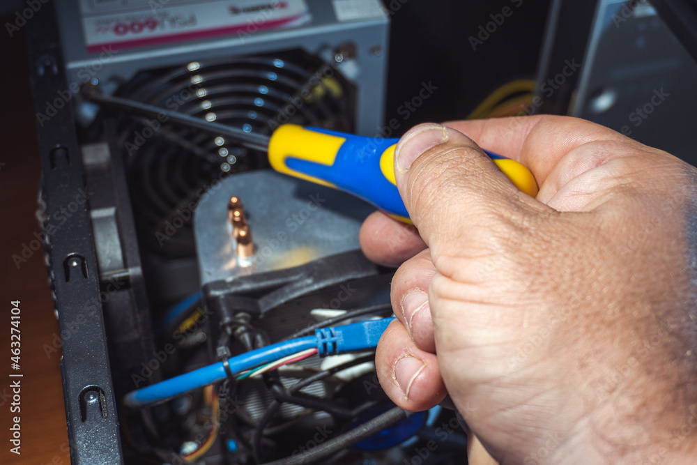 Selective focus of a hand manipulating a precision screwdriver inside a computer's circuitry. Selective focus of a hand manipulating a precision screwdriver inside a computer's circuitry.