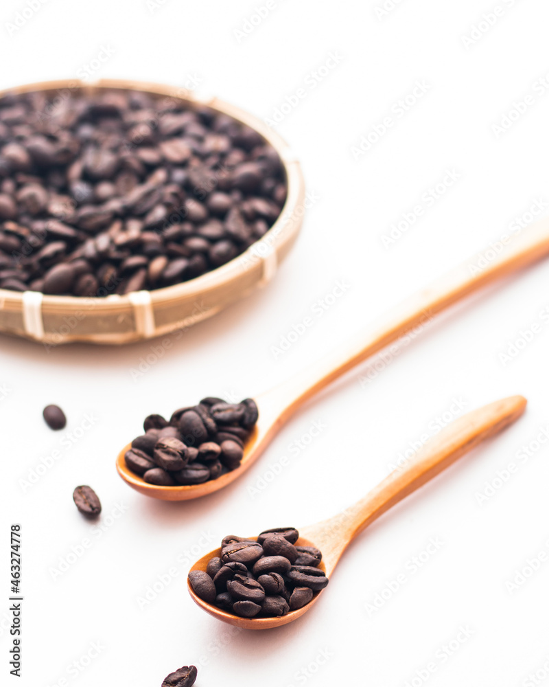 Fototapeta premium coffee beans in a wooden spoon with a basket