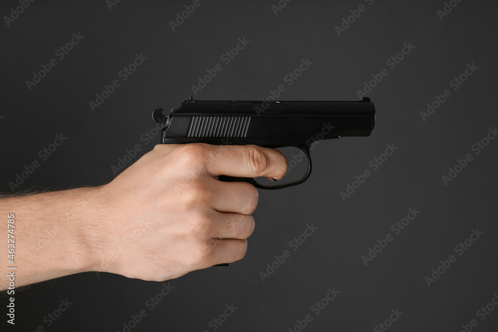 Man aiming gun on dark background, closeup Man aiming gun on dark background, closeup
