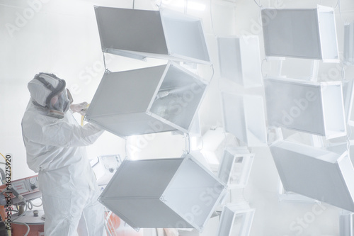 Metalwork workpiece factory paint air spray. Powder coating of metal products. Paint coating industry metal powder coating painting metal parts. Coveralls worker with spray gun painting steel products