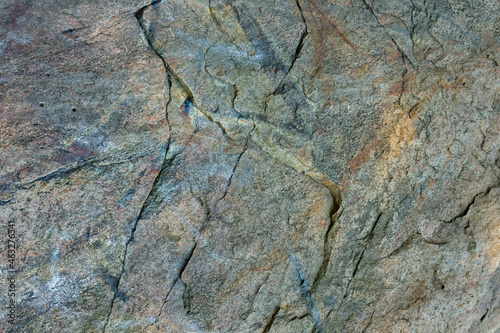 Cracked granite stone texture. Solid rock close-up. Weathered rock