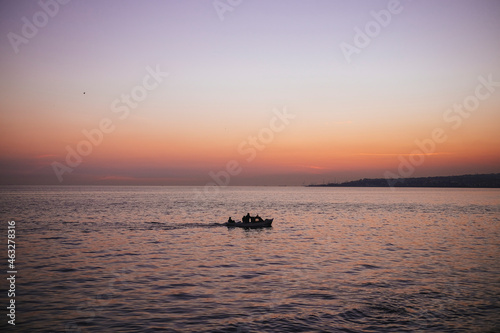small boat on the sea at sunset © BunyaminS