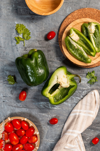 Green peppers with cherry tomatoes on a rustic background