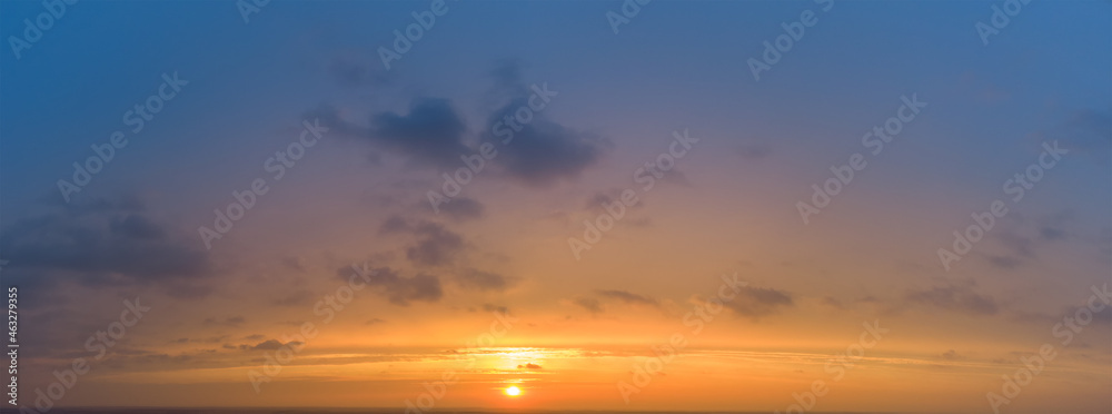 Sunset panorama with blurred colorful sky and orange sun.