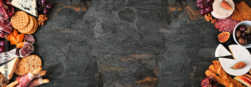 Panel kuchenny z motywem Variety of cheese and meat appetizers. Top view double border on a dark slate banner background with copy space.