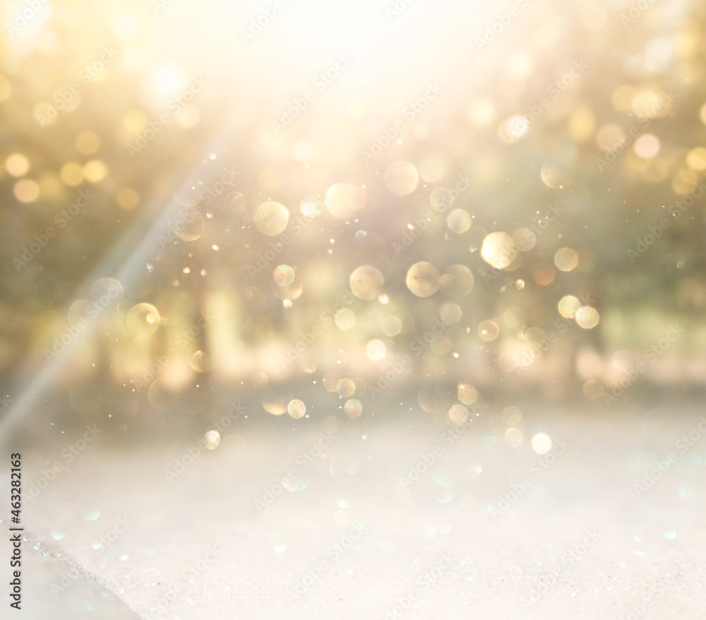 blurred abstract photo of light burst among trees and glitter golden bokeh lights blurred abstract photo of light burst among trees and glitter golden bokeh lights
