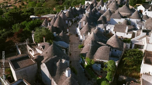 Aerial view of trulli of alberobello town in Italy. drone fly over old town buildings at sunrise
