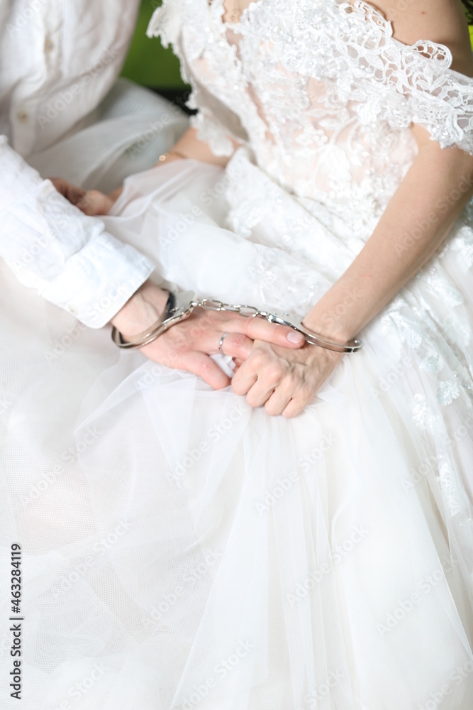 the hands of the newlyweds in handcuffs