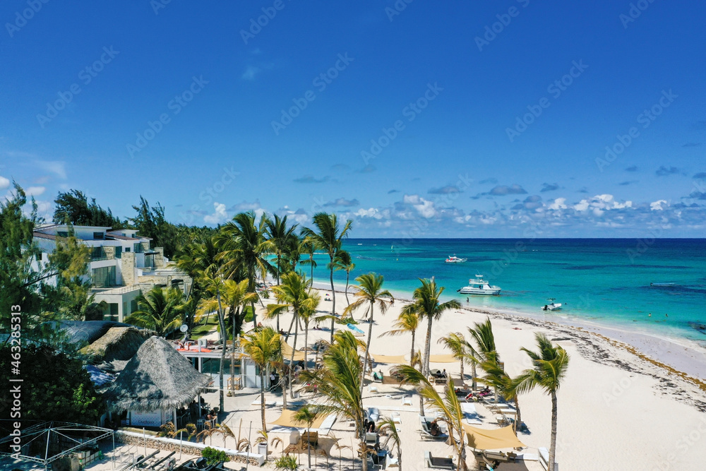 Caribbean sea coastline with Speed boat floating along tropical island with palm trees. Dominican Republic. Aerial view