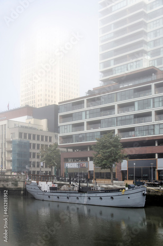 Rotterdam, The Netherlands, October 8, 2021: historic vessel and modern residential towers on a somewaht foggy day in autumn