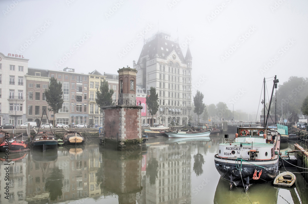 Rotterdam, The Netherlands, October 8, 2021: Wijnhaven harbour with historic vessels and the famous White House on a somewhat foggy day