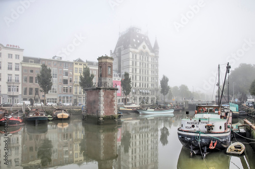 Rotterdam, The Netherlands, October 8, 2021: Wijnhaven harbour with historic vessels and the famous White House on a somewhat foggy day