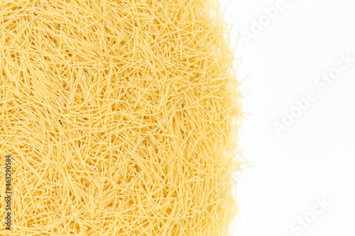 Uncooked vermicelli pasta on white background. Raw dry filini vermicelles. photo