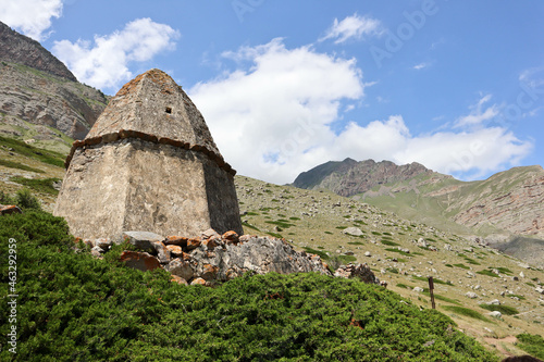 conical old abandoned ancient tombs in "city of dead" necropolis in Eltubu, Chegem Valley, Caucasus, Russia with beautiful mountain landscape