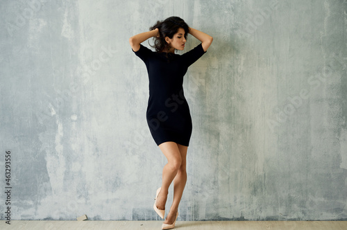 pretty brunette in black dress near the wall posing luxury © SHOTPRIME STUDIO