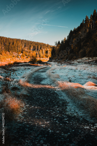 Beautiful sunrise morning with frozen grass meadow landscape and warm light tones. A calm relax outdoor morning in the autumn mountains. Frosty nature morning in the Harz mountains