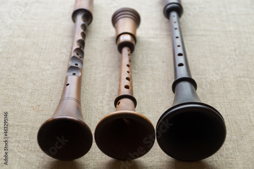 Reconstruction of ancient folk woodwind musical instruments - zhaleika and two schalmeis, located on a gray linen cloth