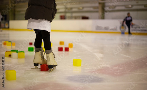 Little girl learns to skate. Children's skates. A child training on ice. The concept of children's figure skating. Children's sports. Winter sport