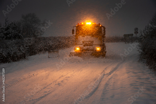 a snow plough operating during a blizzard early morning