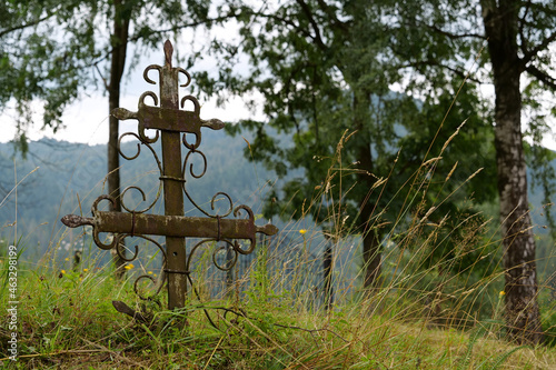 Old rusty cross at old abandoned cemetery photo