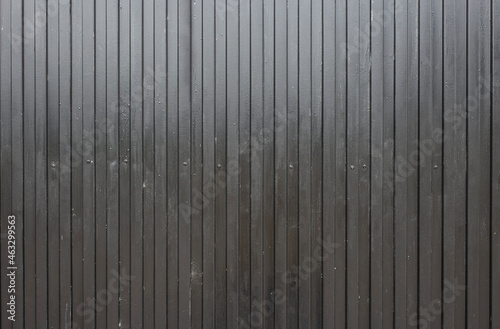 black corrugated metal surface. real image of a used gate. industrial style background.