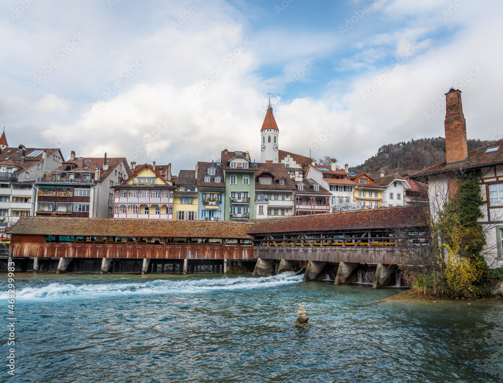 Wooden covered bridge with Thun City Church (Stadtkirche) on background - Thun, Switzerland