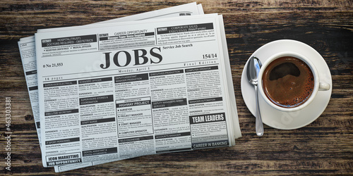 Job classifieds ads newspaper and coffee cup on wooden table. Job search concept.