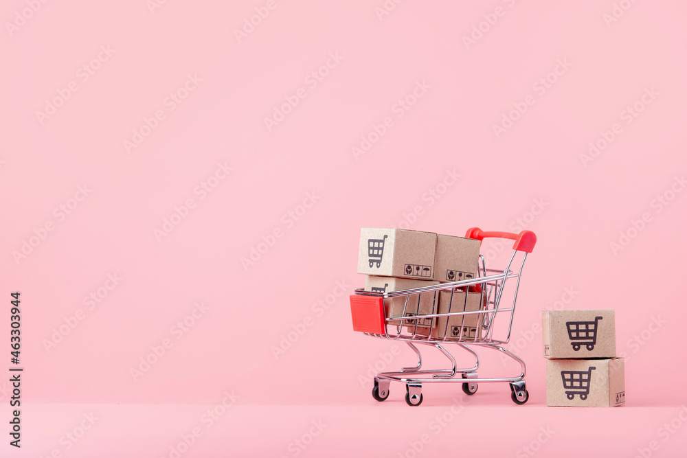 © Achira22 - Shopping concept : Cartons or Paper boxes in red shopping cart on pink background. online shopping consumers can shop from home and delivery service. with copy space © Achira22 - Shopping concept : Cartons or Paper boxes in red shopping cart on pink background. online shopping consumers can shop from home and delivery service. with copy space