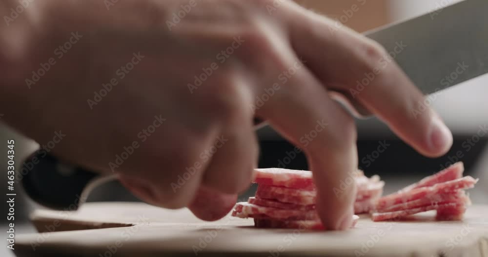 Slow motion man chop salami on olive board Slow motion man chop salami on olive board