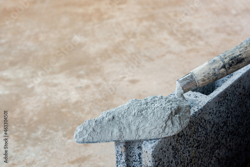 Cement powder or mortar with  trowel put on the Concrete brick for construction work..