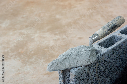 Cement powder or mortar with  trowel put on the Concrete brick for construction work..