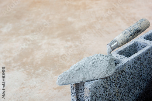 Cement powder or mortar with  trowel put on the Concrete brick for construction work..