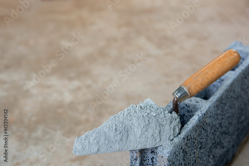 Cement powder or mortar with  trowel put on the Concrete brick for construction work..