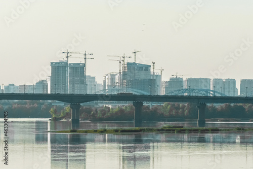 A large bridge to the city across the river against the backdrop of the cityscape and urban landscape architecture © Andrey