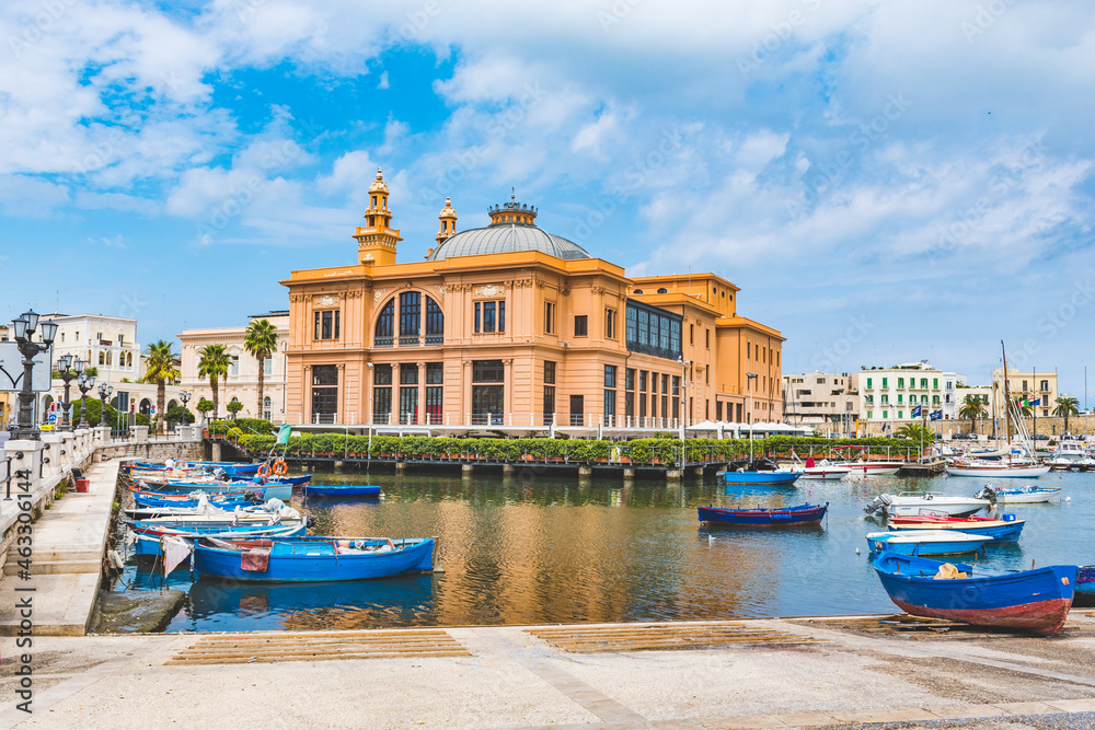 Little Harbor with wooden colorful boats and Margherita theater on the background, Bari, Puglia, Italy