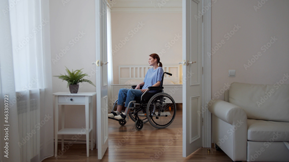 A young disabled woman is riding in her wheelchair around the room A young disabled woman is riding in her wheelchair around the room