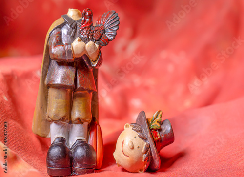 Headless pilgrim celebrates Thanksgiving feast on an orange background
