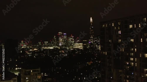 Wallpaper Mural Forwards fly above urban neighbourhood at night. Revealing view of glowing downtown skyscrapers. London, UK Torontodigital.ca