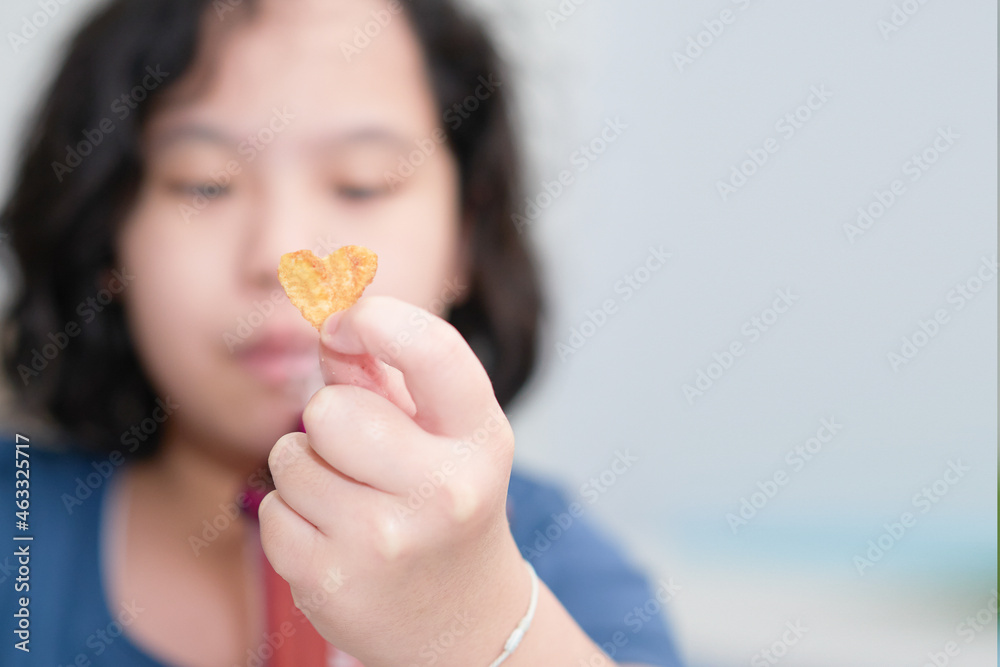 kid hold Korean symbol of love in snack shape isolated on white kid hold Korean symbol of love in snack shape isolated on white