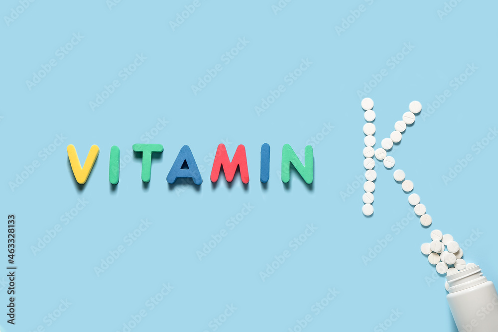 Fototapeta premium Word VITAMIN and letter K made of pills on color background