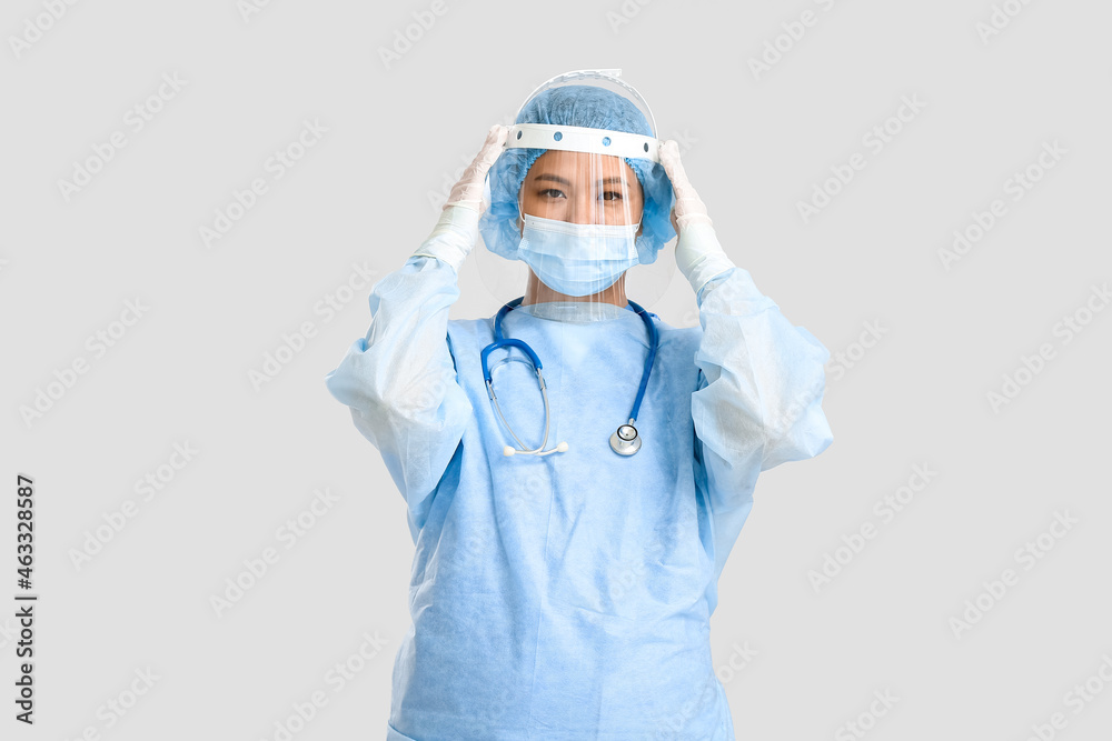 Portrait of female Asian surgeon on light background Portrait of female Asian surgeon on light background