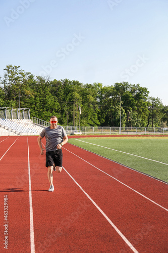 Sporty mature man running at stadium © Pixel-Shot