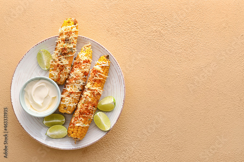 Plate with delicious Elote Mexican Street Corn and mayonnaise on beige background photo